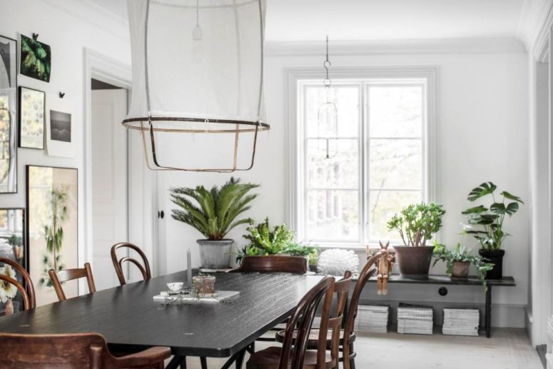 The dining space shows off a gallery wall,  stylish vintage dining set and some books