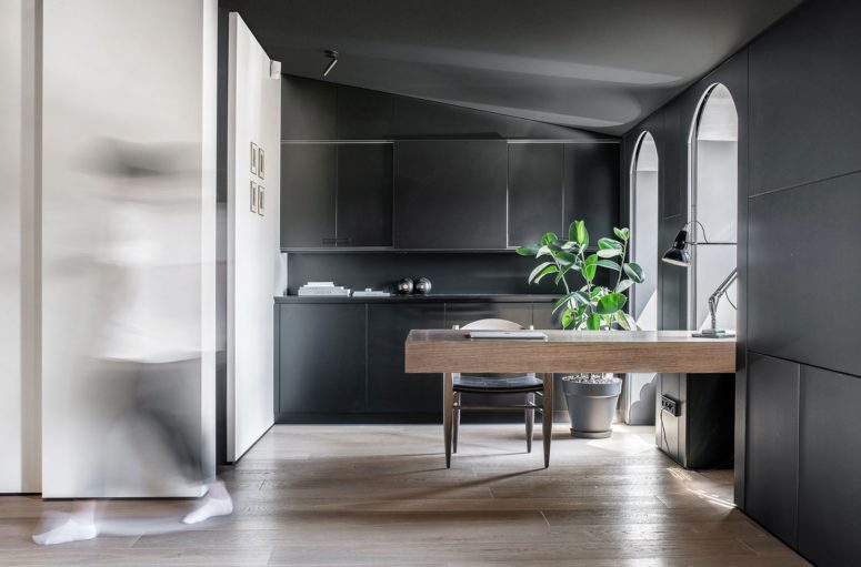 The working space is dark, there's a large floating wooden desk that looks like no other