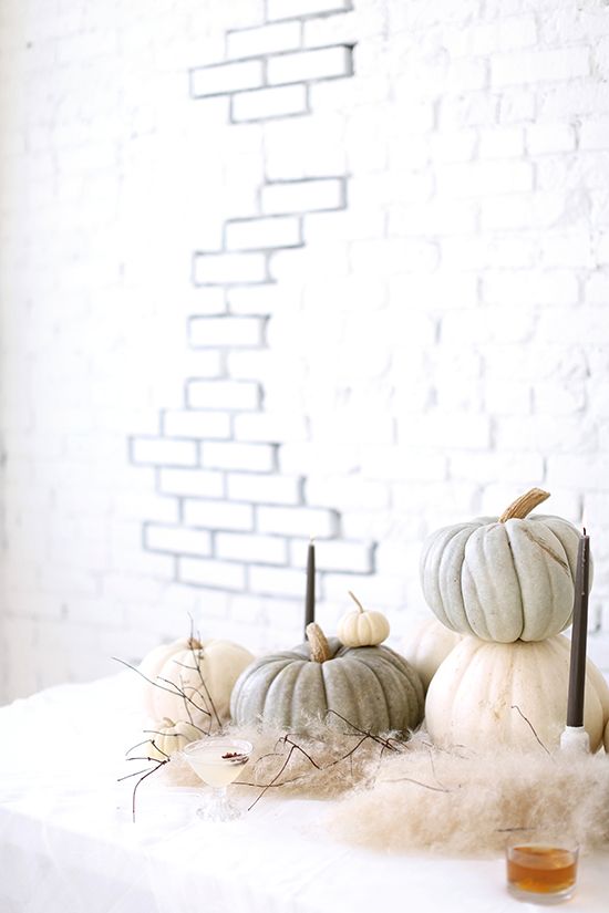 an ethereal Halloween display with naturally colored pumpkins, faux fur and candles plus branches
