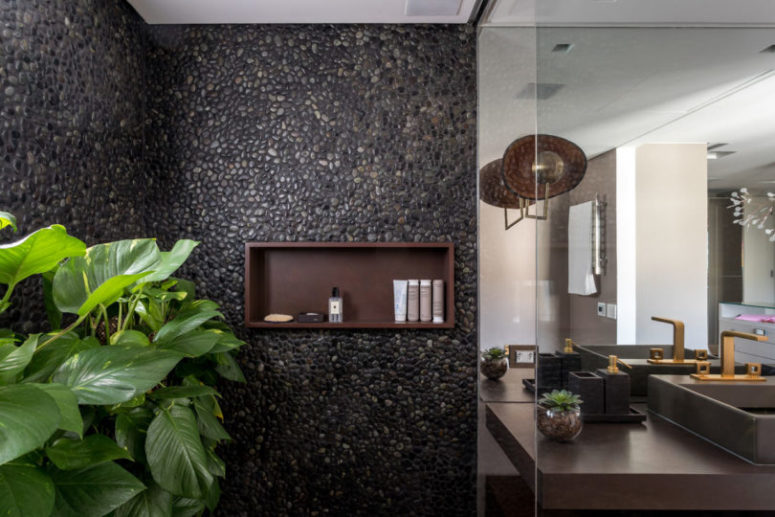 The shower clad with real pebbles and potted greenery make you feel like outdoors
