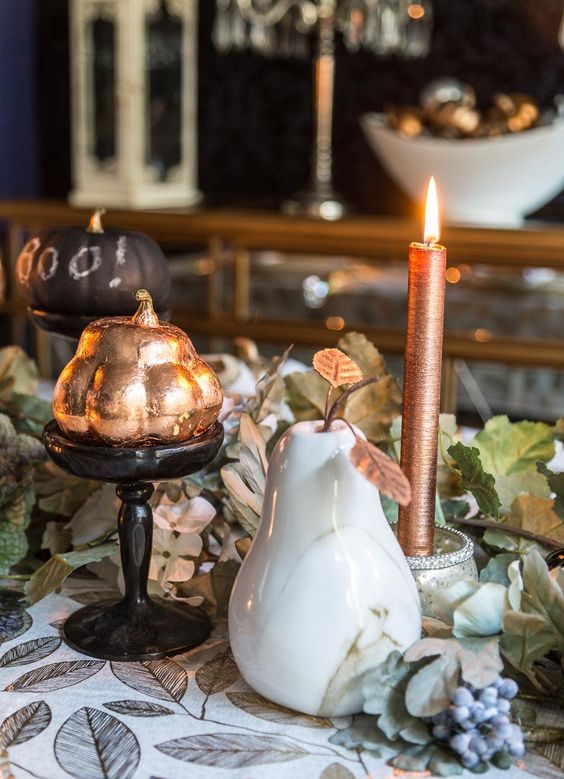 copper candles and faux copper vegetables are great for adding a vintage and rustic feel to the table