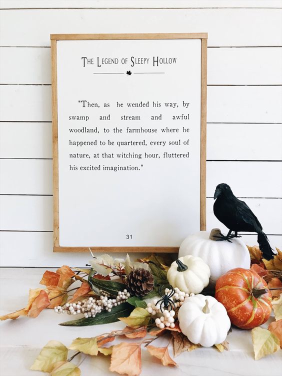 a fall leaf, pinecone and pumpkin arrangement can be topped with a single black bird to feel like Halloween