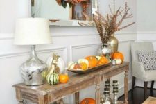 10 a rustic vintage console with real pumpkins, dried bloom wreaths, herbs, scarves and pillows