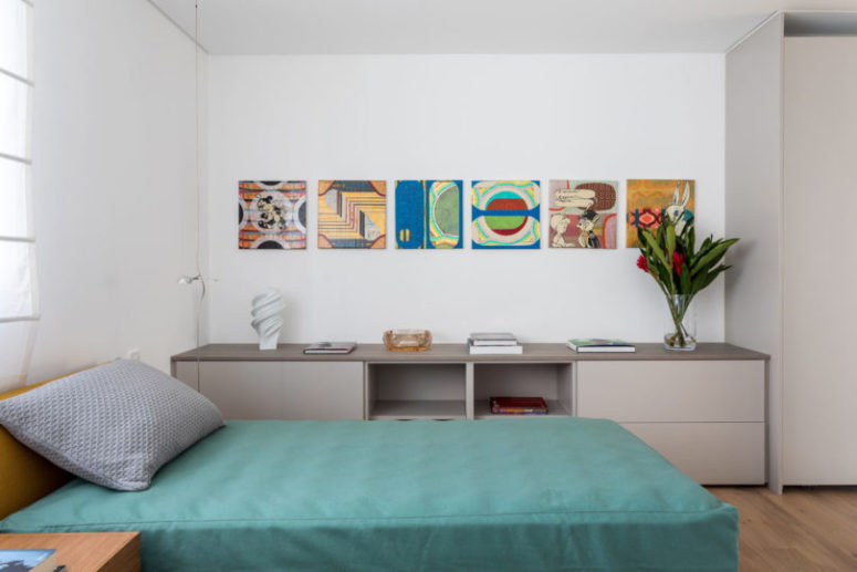 There's also a guest bedroom with a single bed and some storage items plus colorful artworks