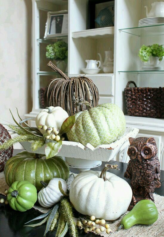 a vintage and rustic centerpiece with faux pumpkins in green and white and of vine is amazing for fall or Thanksgiving decor