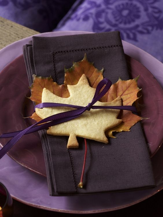 a fall place setting with purple plates and chargers, a fall leaf and a leaf-shaped cookie