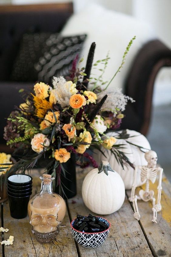 a lush floral centerpiece with fall blooms, greenery and black touches is what you need for a chic look