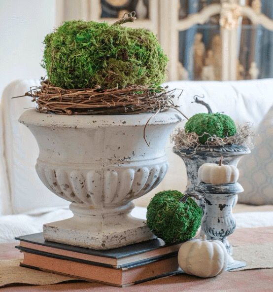 a vintage rustic centerpiece of moss and plastic pumpkins, vine and hay, add vintage books and voila, you have a nice decoration