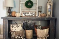 18 a rustic console with fabric and decopuage pumpkins, lavender, a boxwood wreath and scarves with pompoms