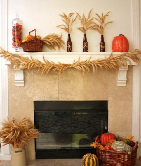 a rustic mantel with wheat, baskets with pumpkins and herbs and fruits in a glass jar
