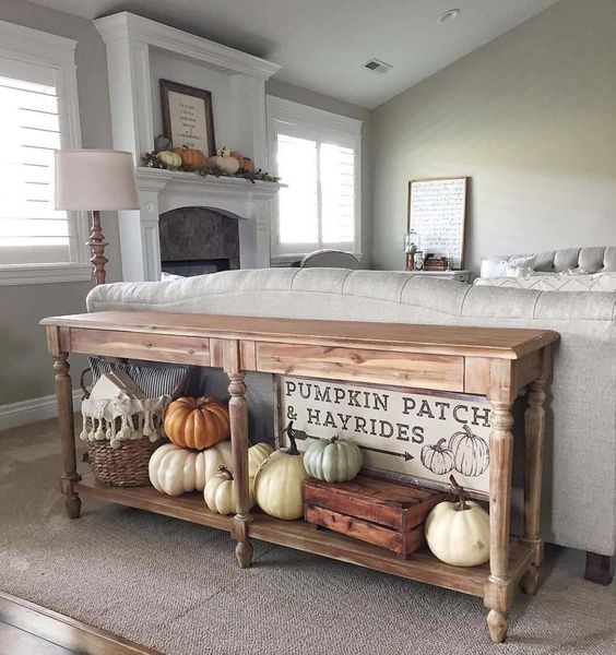 a rustic console with heirloom pumpkins and a basket, plus a cool sign