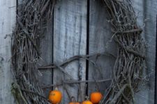 21 a grapevine wreath with little orange pumpkins is all you need to craft for your front door at Halloween