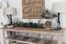 21 a vintage farmhouse console with heriloom pumpkins, metal wire baskets, foliage and a kraft paper sign over it
