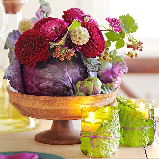 a Thanksgiving centerpiece with a wooden bowl, a purple cabbage, burgundy and fuchsia blooms