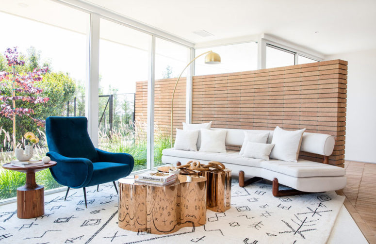 Her'es an outdoor-indoor sitting nook with creative coffee tables and comfy mid-century modern furniture