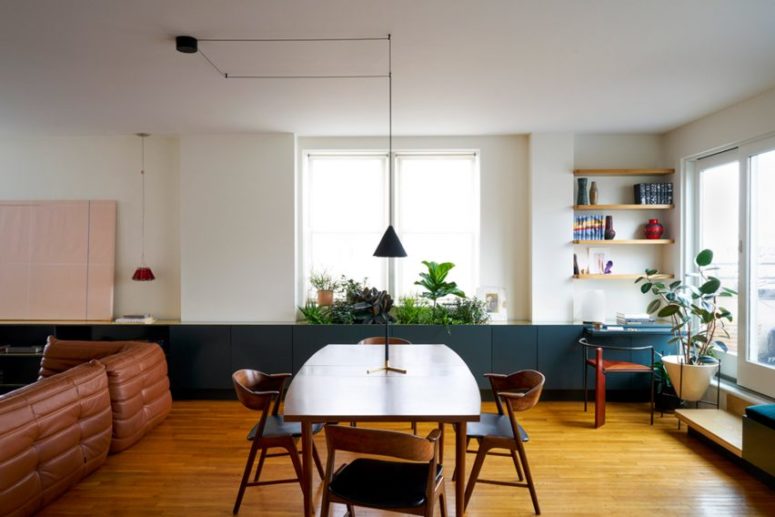 The main space was an open layout with a living and dining space, and a kitchen, too. There is a long row of cabinets in forest green for storage