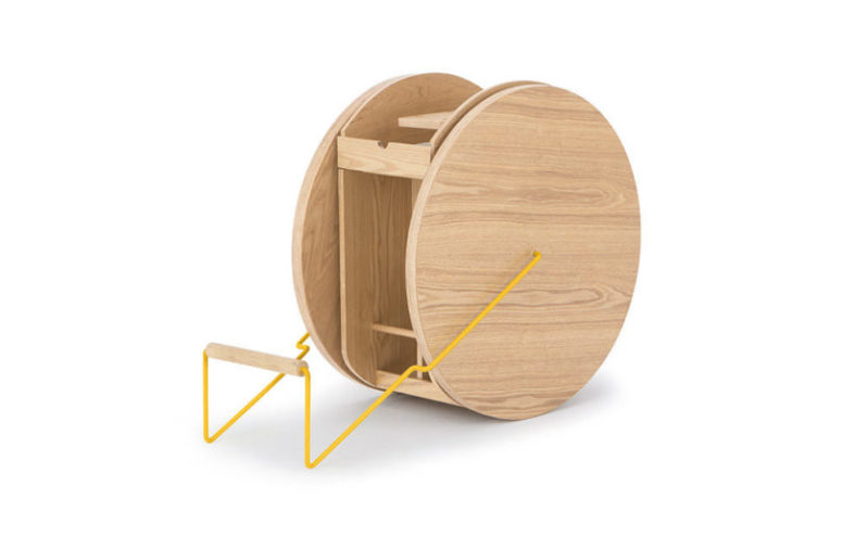 The piece looks like a double circle with some shelves and a stabilizing handle done in bold yellow