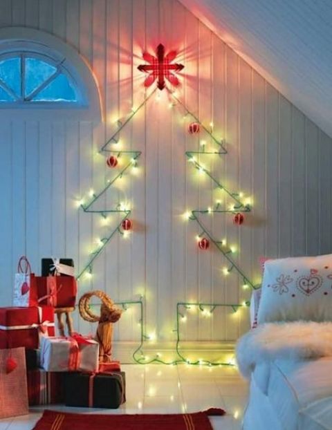 a cute wall-mounted Christmas tree done with green lights and red and white ornaments for a traditional feel