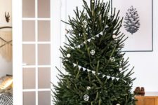 03 a modern Scandi tree with buntings, white and wooden ornaments and a star on top plus lights