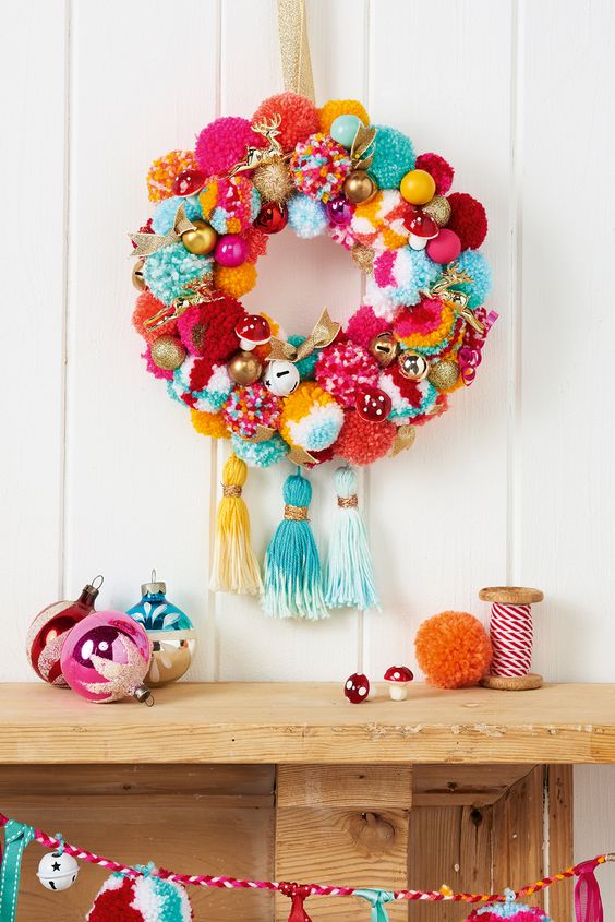 a super colorful and whimsy holiday wreath with pompoms, ornaments, fake mushrooms and large tassels a super colorful and whimsy holiday wreath with pompoms, ornaments, fake mushrooms and large tassels
