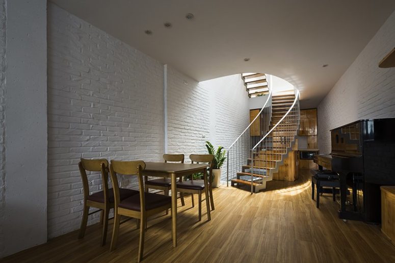 united cooking eating area The dining space and kitchen are united in one space, the kitchen is hidden behind the stairs, and there's a piano