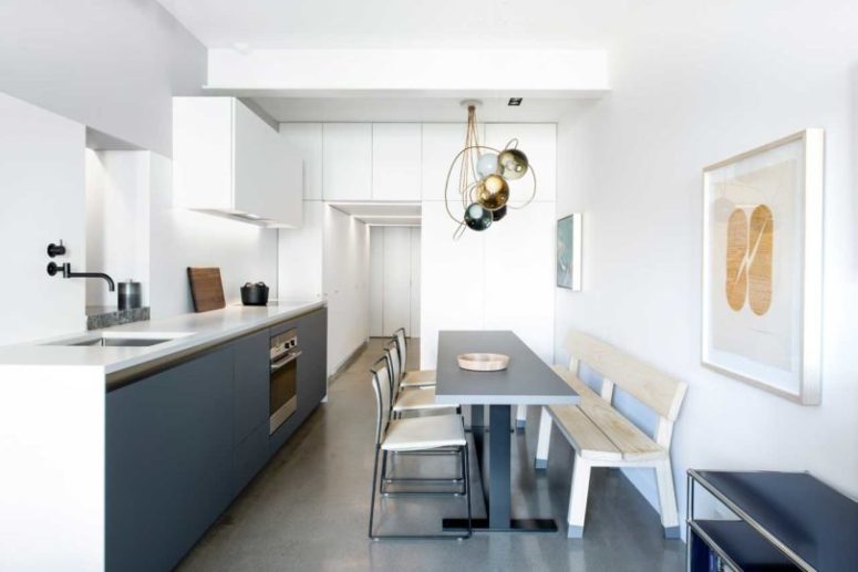 The kitchen is combined with the dining zone and the space looks super laconic and stylish
