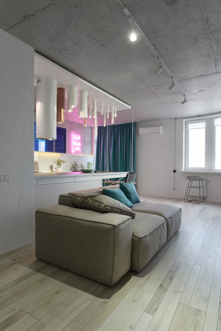 The living room continues the kitchen with a comfy grey sofa with pillows