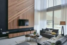 04 a gorgeous contemporary space with oversized windows, a geometric wood clad TV wall and comfy furniture