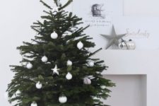04 a modern Scandinavian Christmas tree with white ball and star ornaments in a basket looks very laconic and chic
