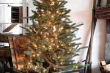05 a Christmas tree placed into a vintage black crate and decorated with lights only is a cool rustic and vintage idea
