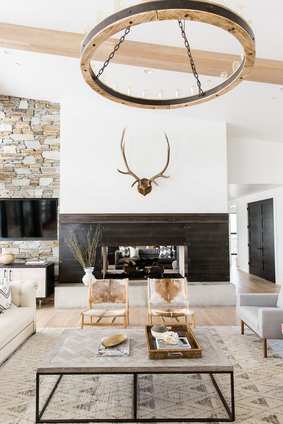 a modern rustic space with jute, fur, wood and stone in decor plus cowhide chairs