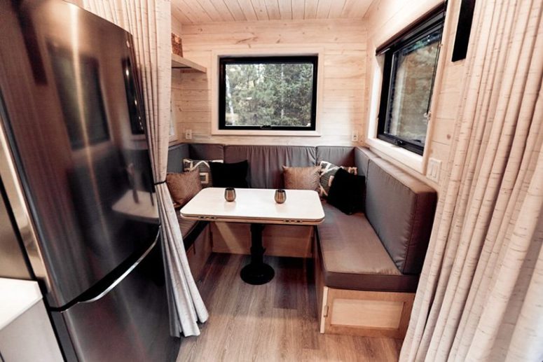 The dining space is also here, it's a small and cozy nook with an upholstered bench and a small table