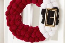 06 a red, black and white pompom Santa-inspired wreath with a large buckle is a fun idea instead of a usual greenery one