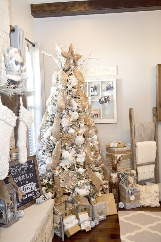 a snowy rustic Christmas tree with lots of burlap ribbons, burlap snowflake ornaments and white ornaments