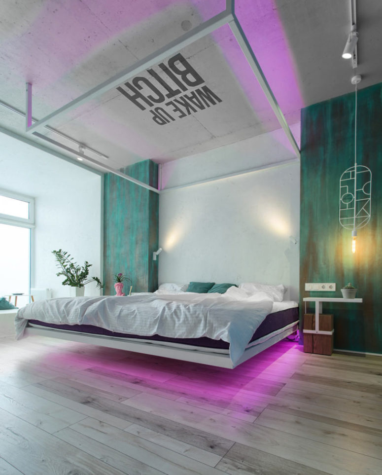 The bedroom shows off a platform bed, a waking inscription on the ceiling and some neon again