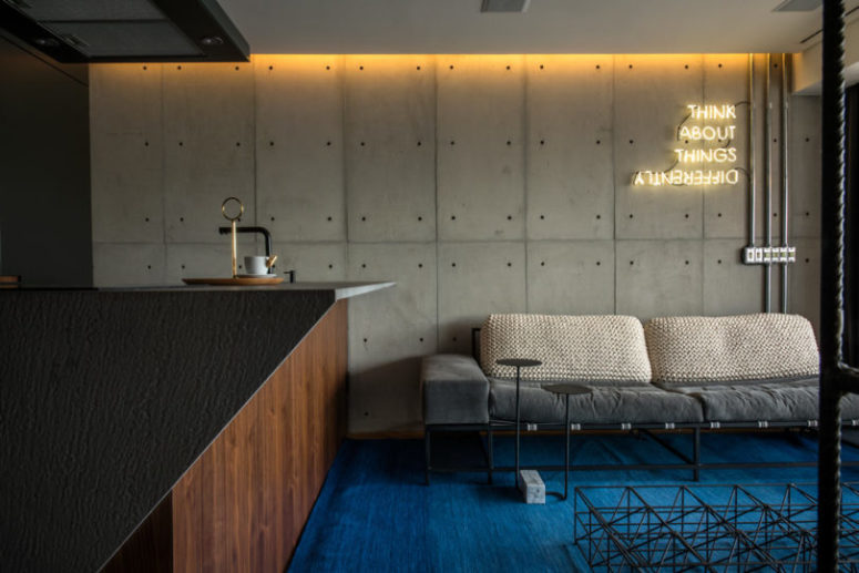 The living space is represented with an industrial sofa and a couple of coffee tables