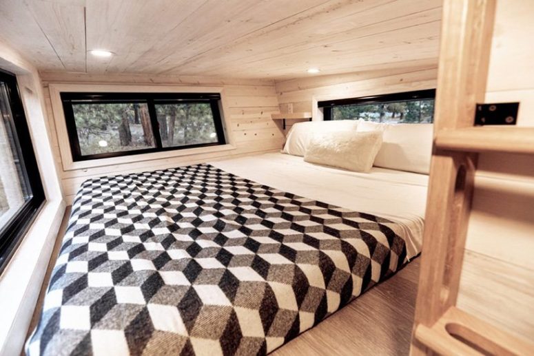The sleeping space is a small one with a bed right on the floor and windows on each side