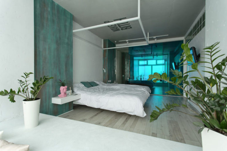 The sliding door is made of emerald glass to match the apartment color scheme
