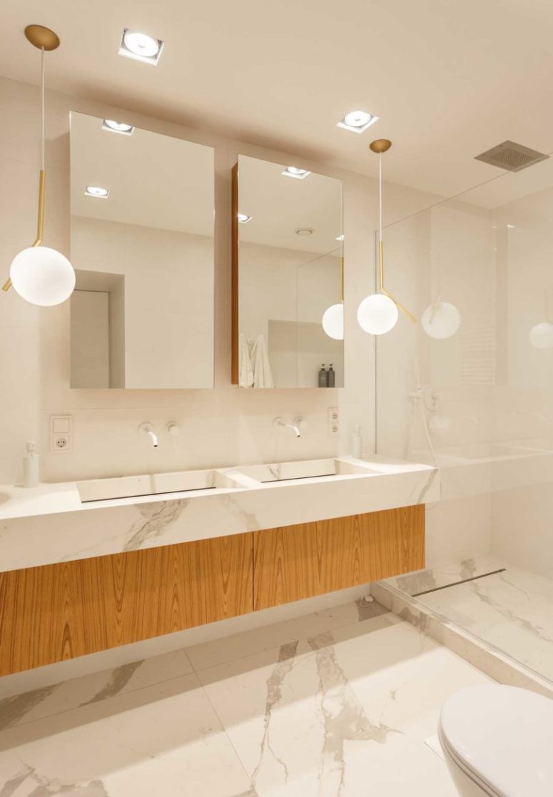 The bathroom is done with a floating vanity, is clad with stone and looks very airy and cool