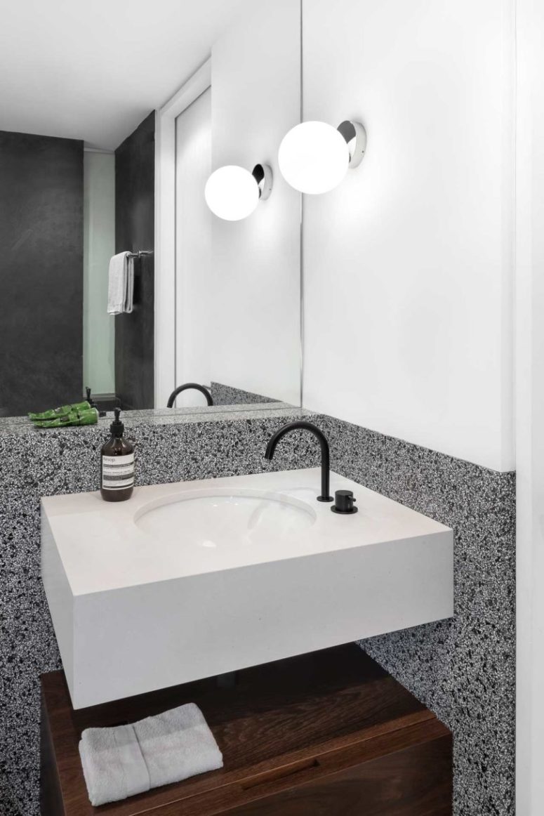 The bathroom is done with stone and concrete, it looks very minimalist and stylish