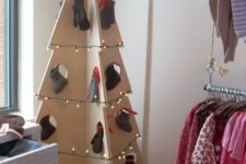 11 a large plywood Christmas tree decorated with lights and mittens hanging in holes for a simple and modern look