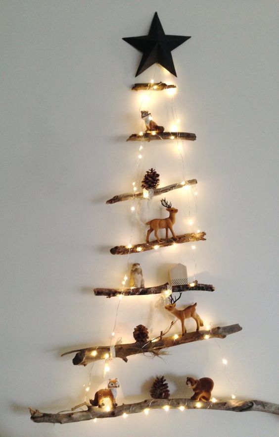 a mini Christmas tree made of branches, lights and decorated with pinecones and little animal figurines