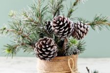 13 a cool Christmas centerpiece or decoration of snowy evergreens and pinecones in a tin wrapped with burlap