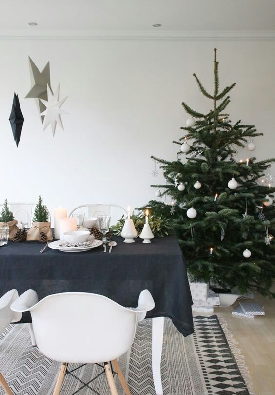 a modern Scandi Christmas tree with white ornaments - stars, snowflakes and balls and some lights