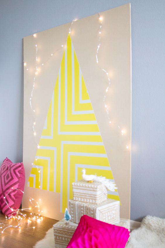 a neon yellow geometric Christmas tree on a plywood sheet with lights around for a colorful space