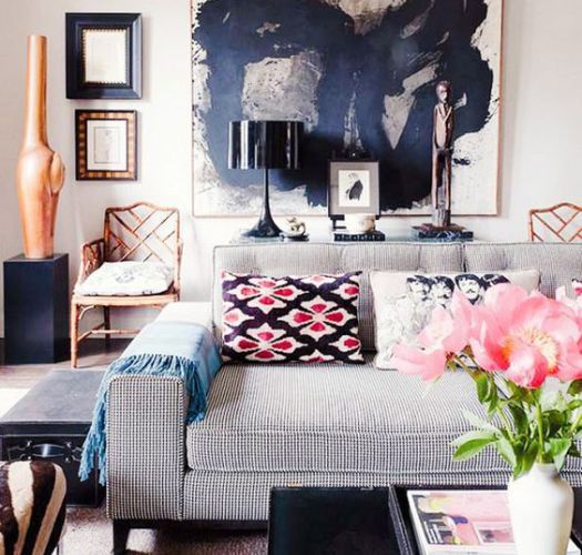a neutral space is made more masculine with a large artwork and is made more feminine with printed pillows and light-colroed metals