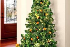 15 a small wall-mounted Christmas tree realized with evergreens, lights, pinecones and real tangerins