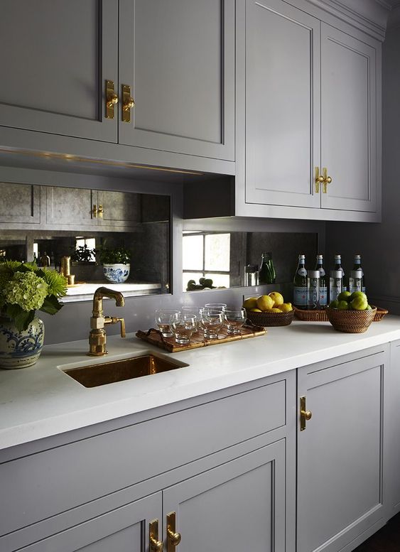 mirror backsplashes are a chic addition to a vintage kitchen, with brass fixtures you'll get a refined look