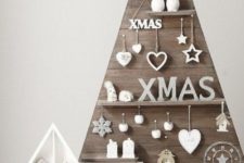 17 a plywood Christmas tree with hooks and shelves and all kinds of decorations located on them
