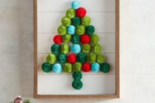 19 a Christmas tree artwork made of colorful pompoms in a frame, it’s very easy to make